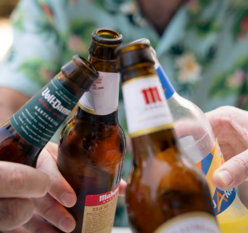 a-group-of-people-holding-up-beer-bottles.jpg a group of people holding up beer bottles